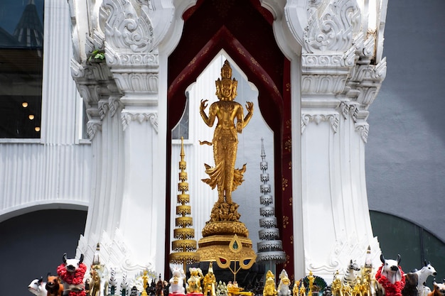 La antigua estatua del dios trimurti o la figura de la trinidad suprema del señor en el santuario para los tailandeses, los viajeros, los viajes, la visita y el respeto, la bendición de la oración sagrada en el patio del mundo central en Pathumwan en Bangkok, Tailandia