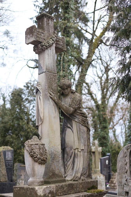 Foto una antigua estatua en una lápida en un cementerio o cementerio cristiano