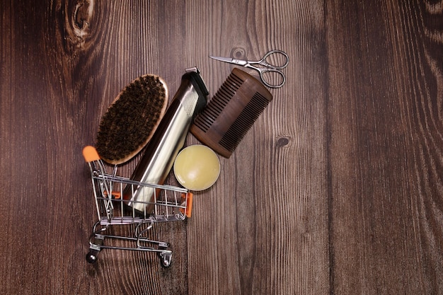 Antigua herramienta de peluquería vintage sobre un fondo de madera antiguo. Peine para barba de madera vintage, aceites para barba.