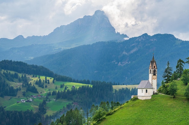 La antigua iglesia de Santa Bárbara en un lugar pintoresco en La Val, Val Badia, en el corazón de los Dolomitas