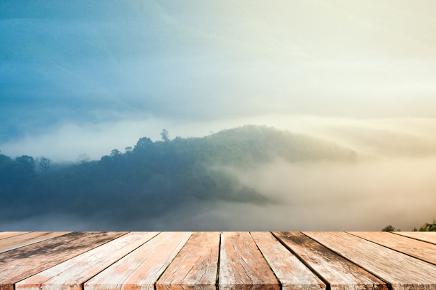 Antigua mesa de madera en blanco con montañas y niebla