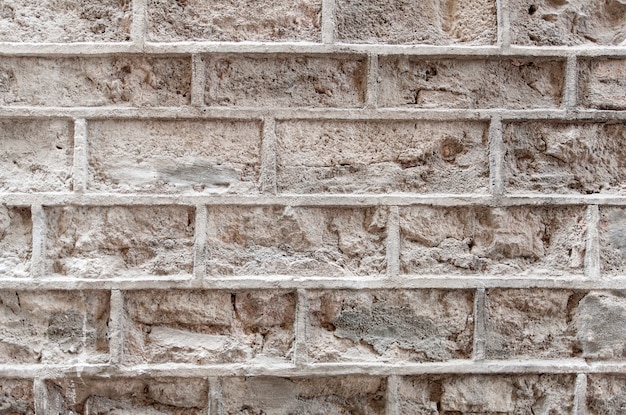 Antigua muralla de ladrillo con pintura blanca