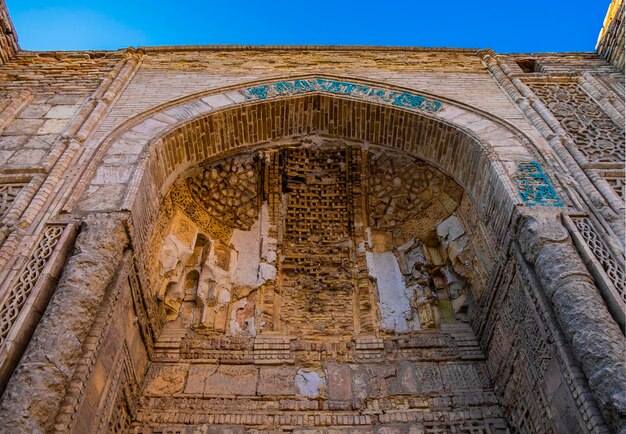Foto la antigua pared de ladrillo y el arco como parte del edificio del museo de tejido de alfombras de bukhara, uzbekistán