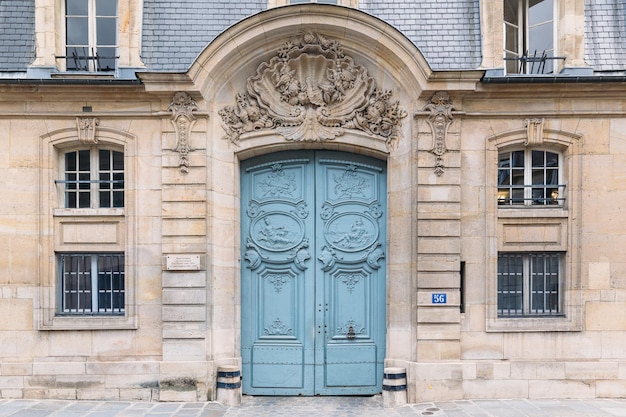 Antigua puerta de madera azul con bajorrelieve en París Francia Característica de la arquitectura Exterior del edificio