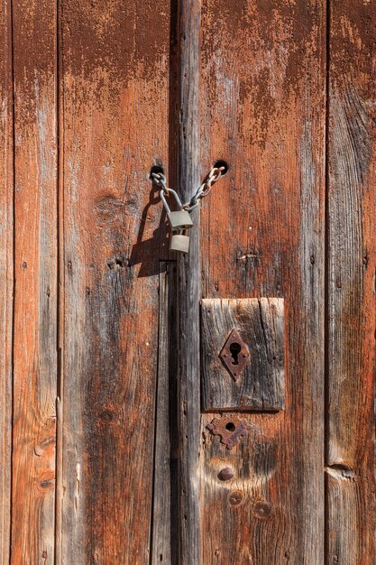 Antigua puerta de madera con cerradura y cadena.