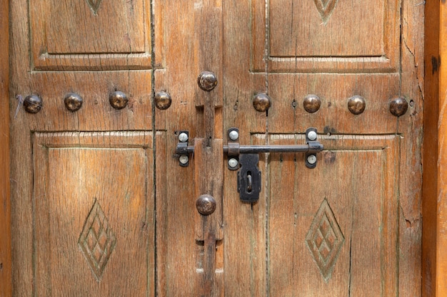 Una antigua puerta de madera con perno metálico, de cerca, de Arabia