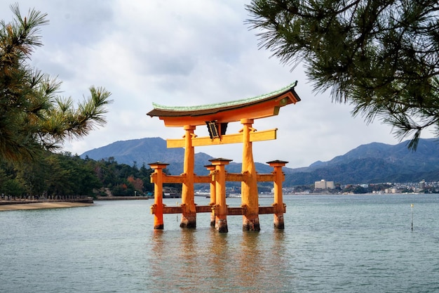 Antigua puerta torii de madera en el mar medio del patrimonio mundial de la unesco