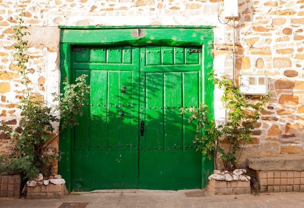 Antigua puerta verde de una pobre casa española