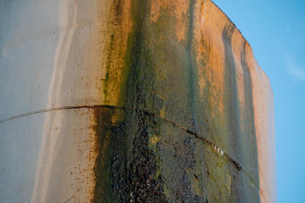 Una antigua torre de agua con fugas El agua fluye de un gran barril de hierro Construcción metálica rota