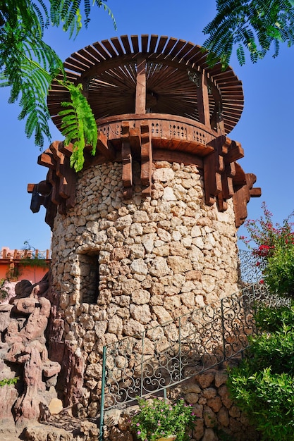 Antigua torre de fortaleza de piedra antigua con árboles en el frente Foto de alta calidad