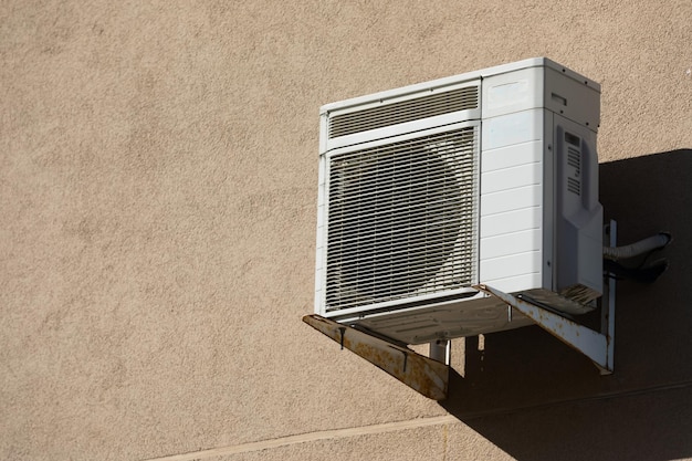 Antigua unidad de aire acondicionado exterior colgando fuera del edificio