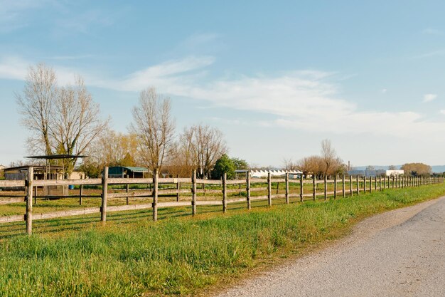 Una antigua valla de madera con un campo verde detrás