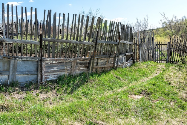 Una antigua valla de madera en una parcela de pueblo abandonada