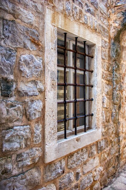 Antigua ventana con barras en un castillo de piedra