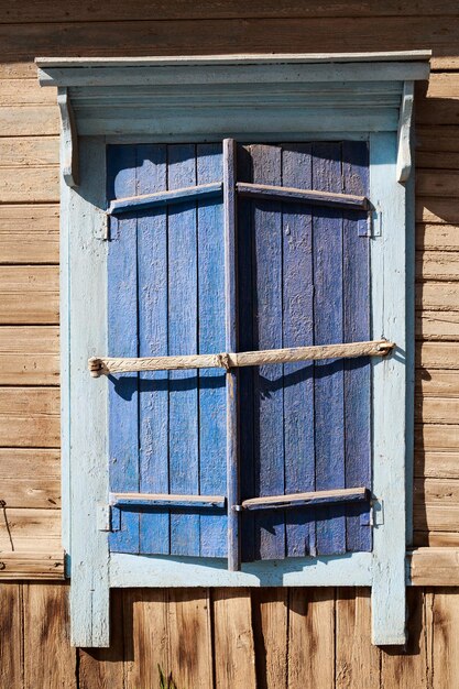 Antigua ventana de madera azul vintage con persianas cerradas en Rusia