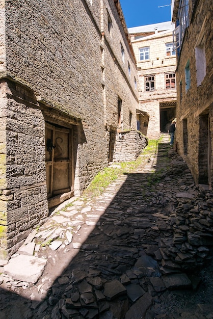 Foto antigua vivienda abandonada una calle estrecha entre muros de piedra