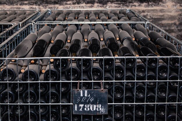 Antiguas botellas de vino envejecidas en bodega en hileras