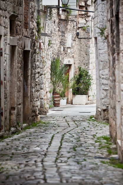 Antiguas calles estrechas de piedra de Trogir, Croacia. Tiro vertical