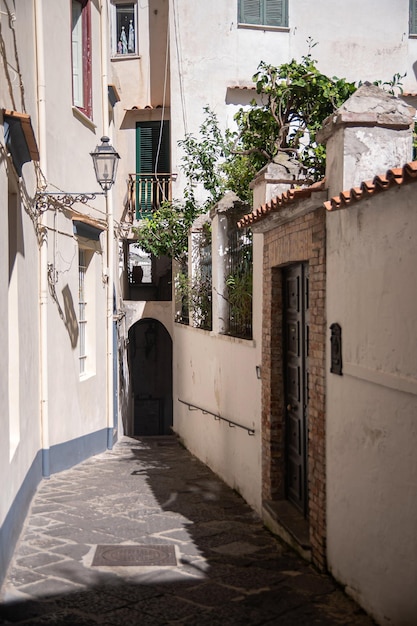 Antiguas calles históricas y románticas en mal estado del sur de Italia en la ciudad de Amalfi Las calles estrechas y antiguas dan vuelta a las puertas inundadas de sol de verano