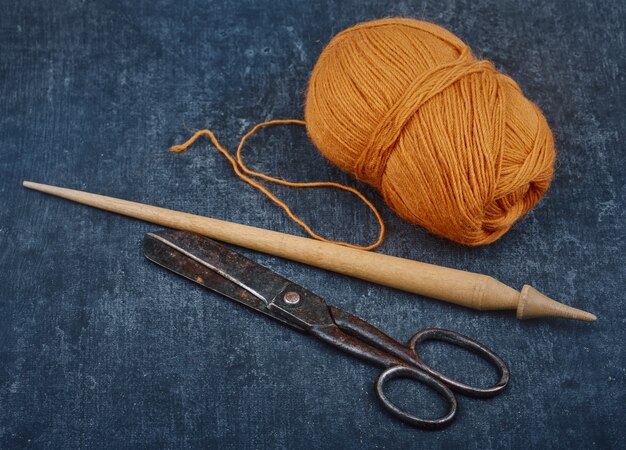 Antiguas herramientas de sastrería usadas y una madeja de hilo de lana