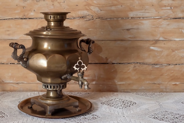 Foto antiguidade de samovar de bronze russo em uma mesa de madeira