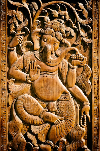 Antiguo bajorrelieve Ganesha con motivos florales tallados en madera