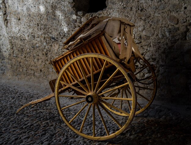 Antiguo carro de madera para labores agrícolas bien conservado descansando sobre un suelo de piedra de una casa rural