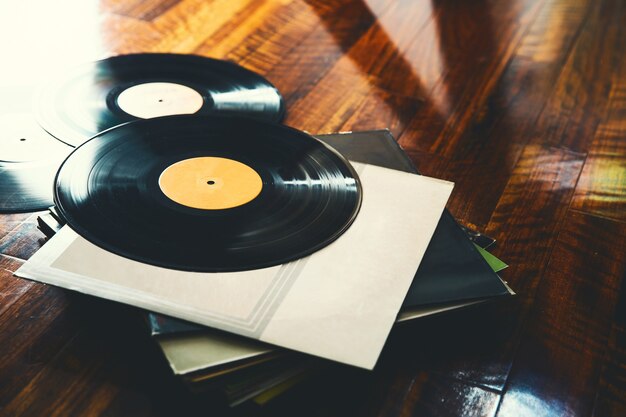 Antiguo disco de vinilo y una colección de álbumes sobre fondo de madera