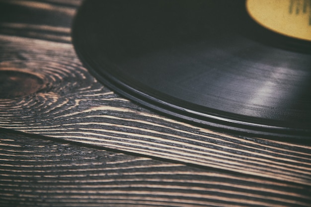 Antiguo disco de vinilo sobre la mesa de madera.