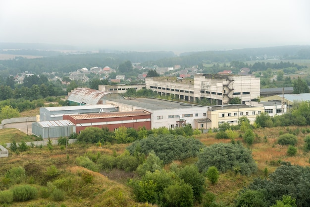 Antiguo edificio de fábrica abandonado en medio de un bosque verde Panorama de la ciudad con fábricas