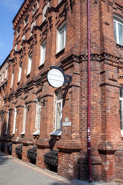 Un antiguo edificio grande de ladrillo con un letrero blanco para el nombre de una cafetería o tienda.