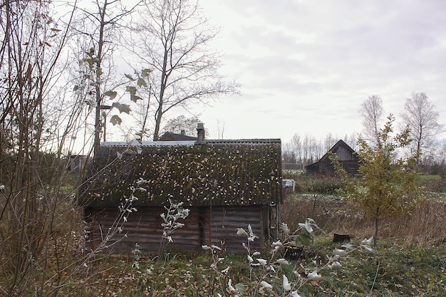 Antiguo edificio de madera de la casa de baños en el pueblo en el campo con hojas de otoño. Exterior tradicional de estilo ruso.