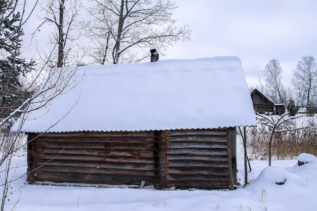 Antiguo edificio de madera de casa de baños en el pueblo en día de invierno. Exterior tradicional de estilo ruso.