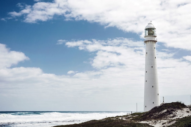 Antiguo faro en la orilla bajo un cielo nublado en Ciudad del Cabo, Sudáfrica