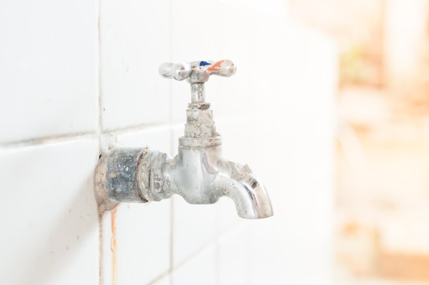 Antiguo grifo de agua oxidado en la escuela Antiguo grifo de agua al aire libre y gotas de agua