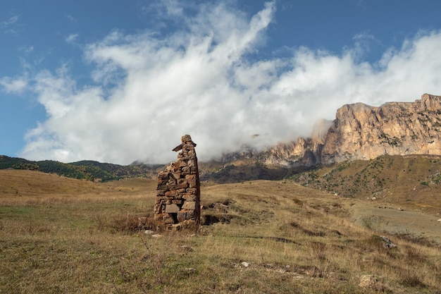 Un antiguo ídolo de piedra en el fondo de montañas brumosas Lápidas hechas de piedra SturDigora región Osetia del Norte