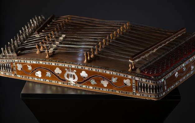 Antiguo instrumento musical de cuerda asiático sobre fondo negro con retroiluminación