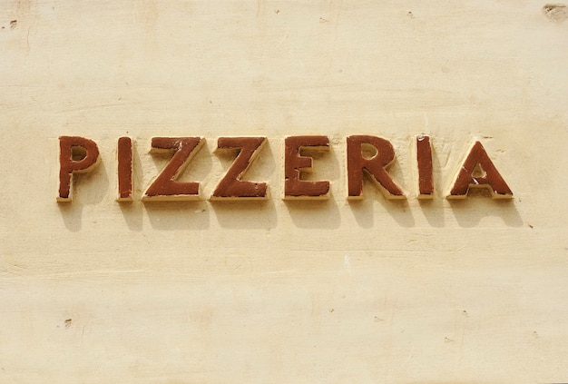 Antiguo letrero de pizzería en una pared en Italia Hecho a mano en material cerámico