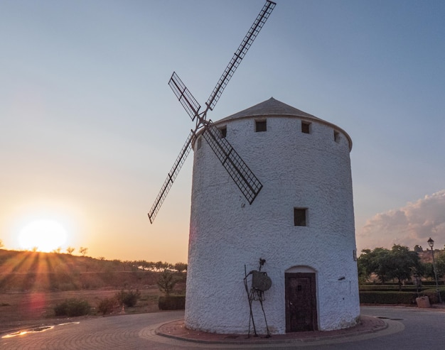 Antiguo molino de viento con la figura de Don Quijote de la Mancha fotografía tomada al atardecer