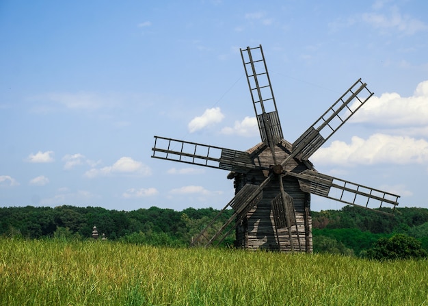 Antiguo molino de viento de madera en un prado verde