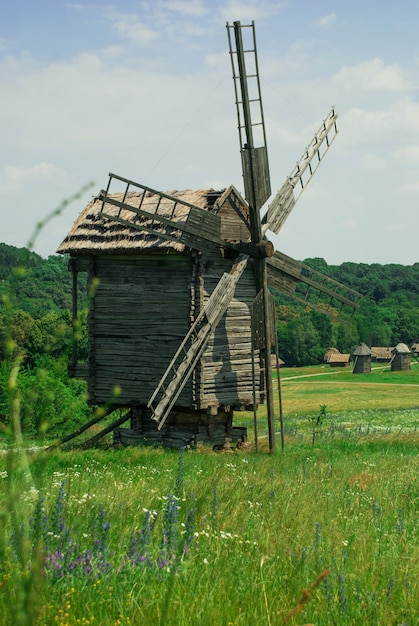 Antiguo molino de viento de madera en un prado verde