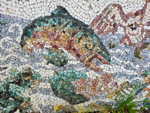 Antiguo mosaico de piedra de colores de peces y aves