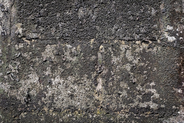 Antiguo muro de cemento gris con grietas en la superficie