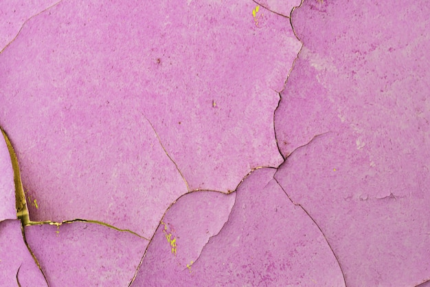 Antiguo muro de piedra con pintura violeta agrietada. Foto de alta calidad