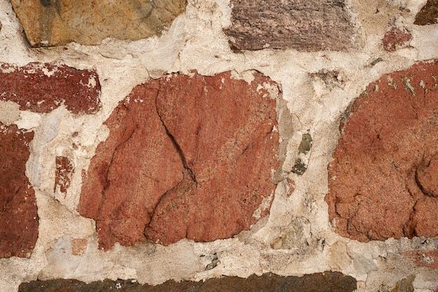 Un antiguo muro de piedras de granito de diferentes tamaños como fondo.