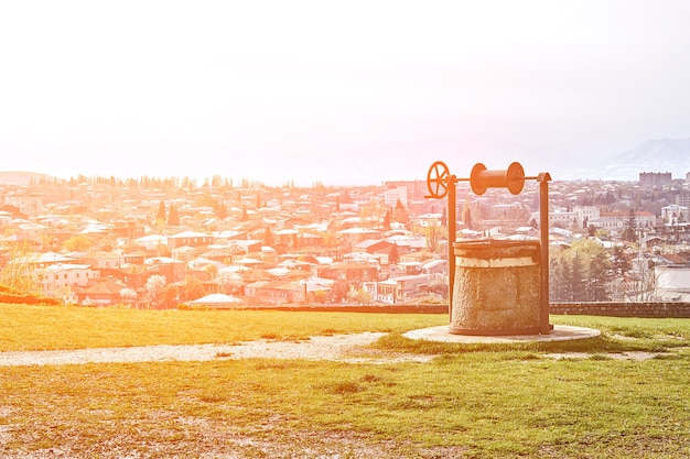 Antiguo pozo retro en el fondo del panorama de la ciudad kutaisi georgia sun flare