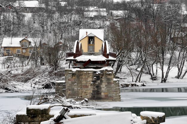 Antiguo puente de carretera de acero en ruinas sobre el río después de las nevadas