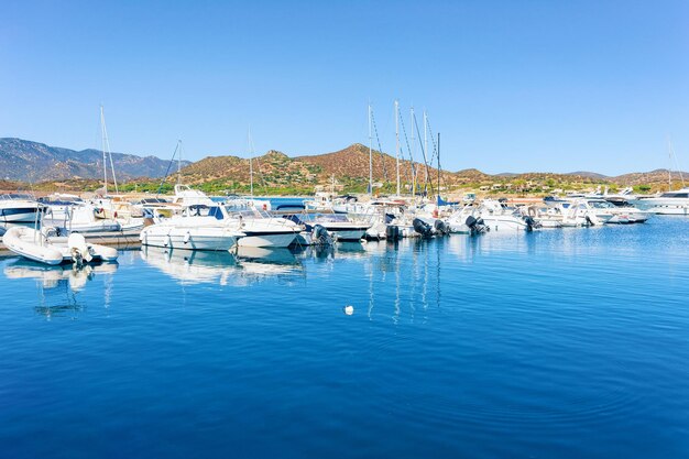 Antiguo puerto de Cerdeña y puerto deportivo con barcos en el mar Mediterráneo en la ciudad de Villasimius en la isla de Cerdeña del Sur en Italia en verano. Paisaje urbano con yates y barcos