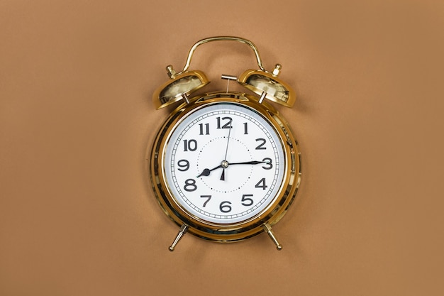 Antiguo reloj de alarma sobre un fondo marrón