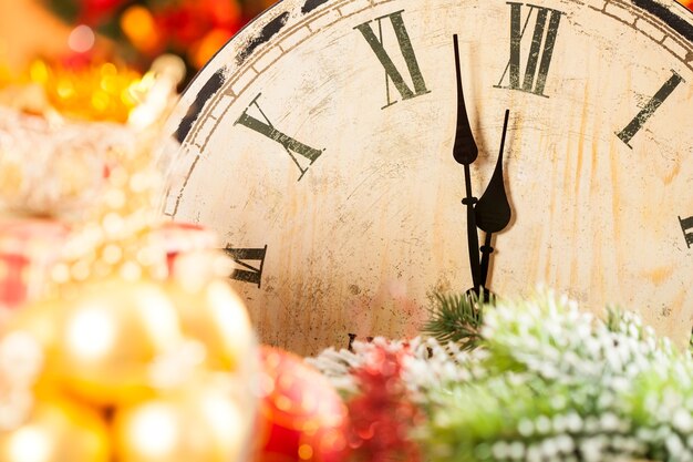 Antiguo reloj de madera contra luces navideñas. Concepto de año nuevo